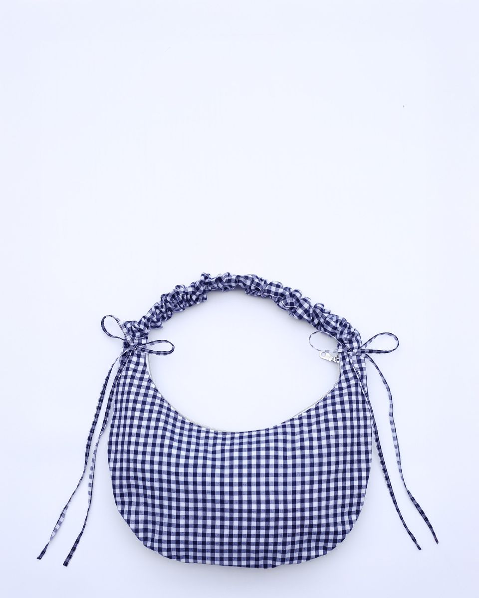 The Drawstring Crescent Bag with its strap short (scrunched up).