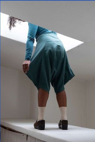 Person standing with head in a skylight showing the back view of the Leija trousers in teal.