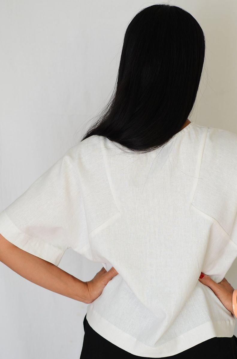 Back shot of model wearing top made in white fabric