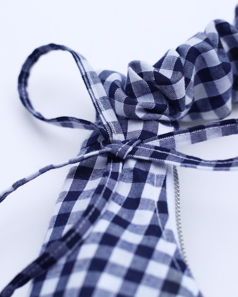 The drawstrings gathering the strap are tied into bows.