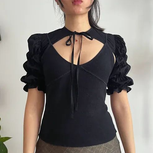 Front view of the Dahlia Bolero in black fabric modelled on the pattern designer.
