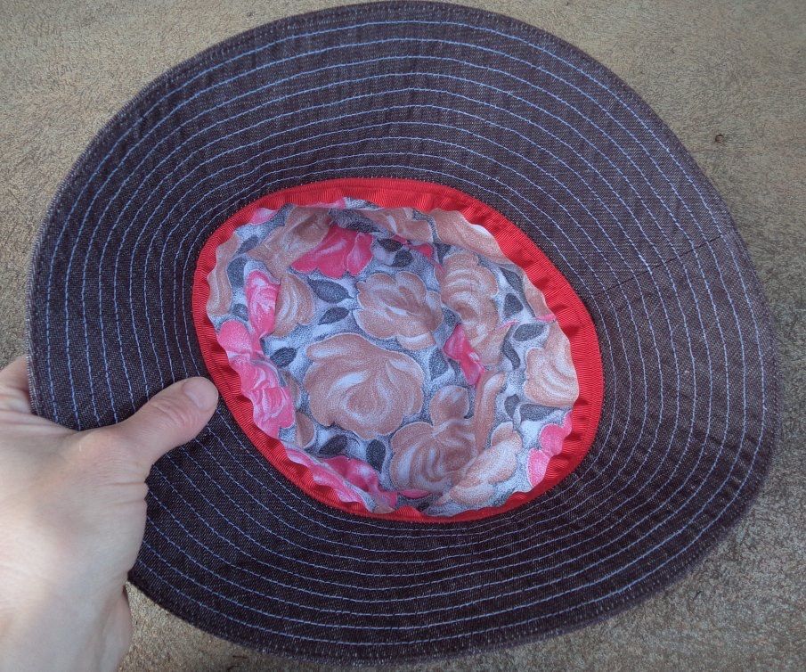 Underside of the brown hat, the interior lining is made of a floral fabric. The grosgrain ribbon is assorted to the pink flowers.